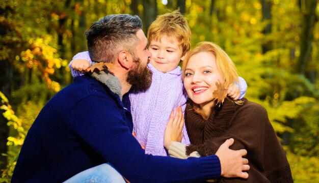 Mère, père et fils en automne marchent dans le parc. Famille heureuse. Parents et enfants se détendre ensemble en journée ensoleillée.