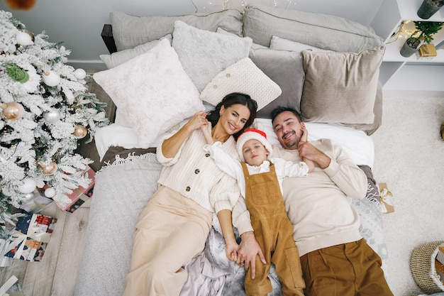 Mère père et fils s'amusant sur le lit le jour de Noël