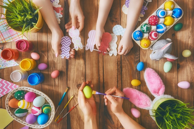 Une mère père et leur enfant peignant des oeufs Famille heureuse se préparant pour Pâques