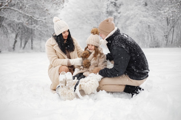 Mère père et leur petite fille jouant à l'extérieur le jour de l'hiver