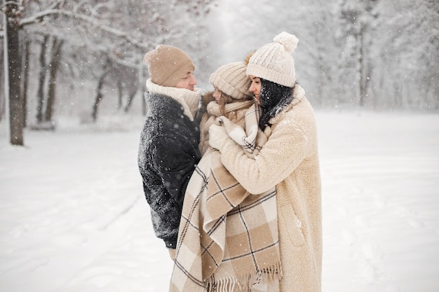 Mère père et leur petite fille jouant à l'extérieur le jour de l'hiver