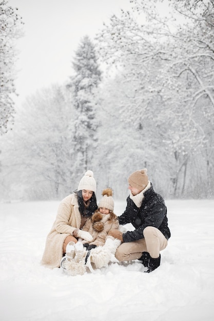 Mère père et leur petite fille jouant à l'extérieur le jour de l'hiver