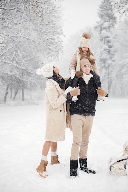 Mère père et leur petite fille jouant à l'extérieur le jour de l'hiver