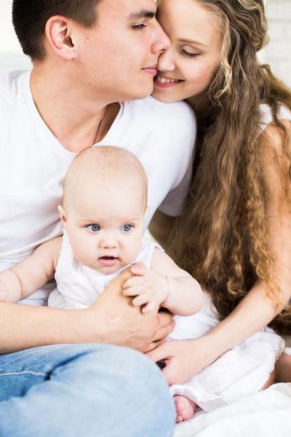 Mère et père avec petit bébé dans un lit