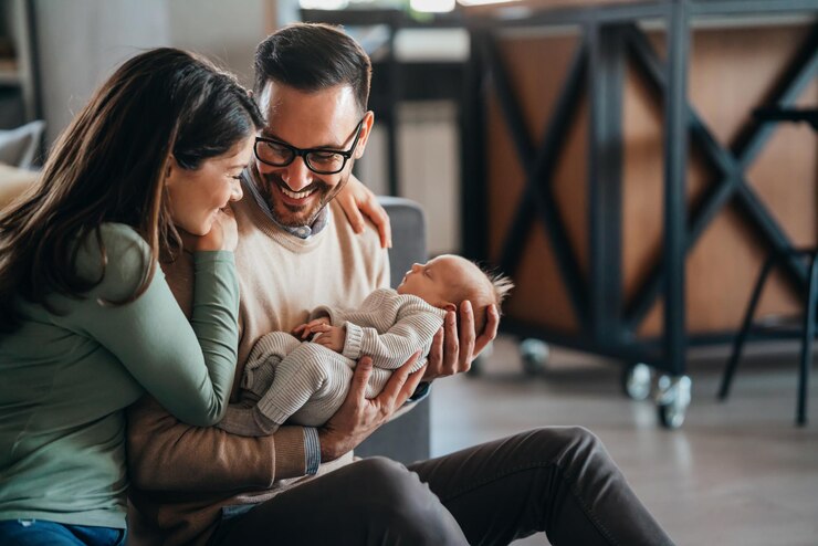 Photo une mère et un père souriants tenant leur petite fille nouvellement née à la maison