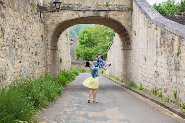 Mère et petit beau garçon jouant en plein air dans la vieille ville