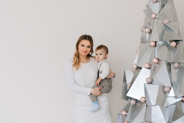 mère avec petit fils près de l'arbre de Noël