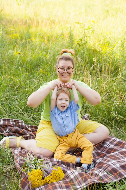 Une mère et un petit garçon handicapé s'embrassent et jouent dans la nature Handicap Paralysie infantile Amour maternel Enfance heureuse