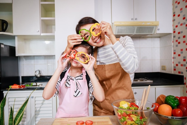 Mère et petite fille aiment préparer les légumes et les fruits dans la cuisine à la maison Alimentation saine