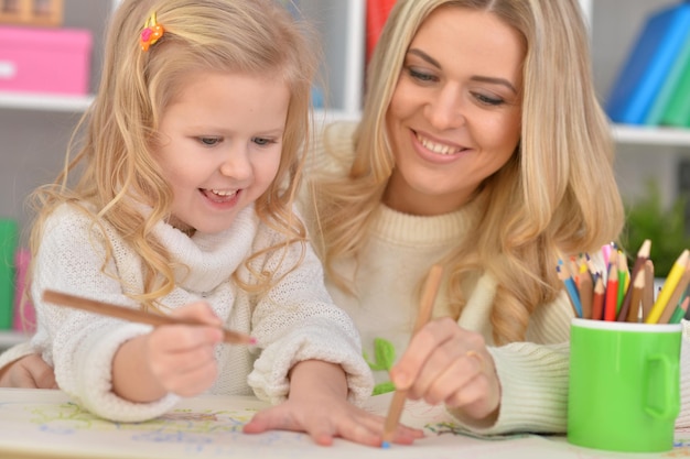 Mère avec petite fille dessinant avec des crayons colorés