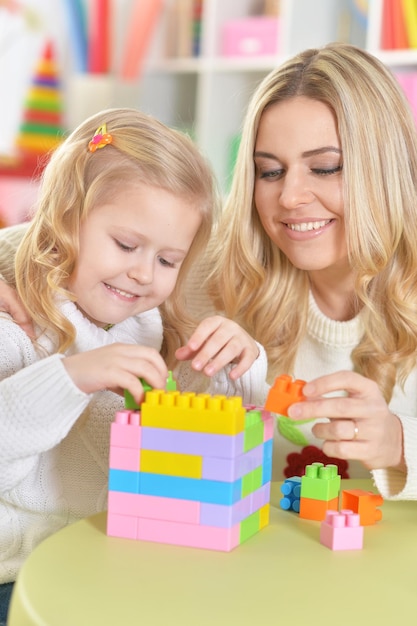 Mère avec petite fille faisant des figures avec constructeur