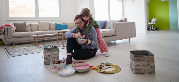 Mère et petite fille jouant avec des bijoux tout en restant à la maison en quarantaine du coronavirus