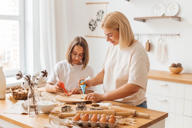 Mère et petite fille préparent des biscuits et s'amusent dans la cuisine