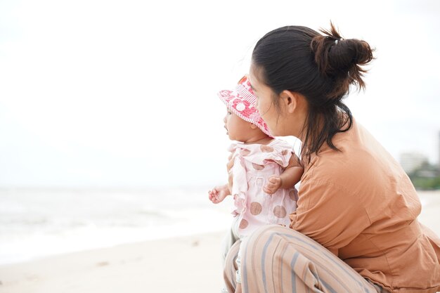 Mère et petite fille profitant de la plage. Belles vacances d'été en famille.