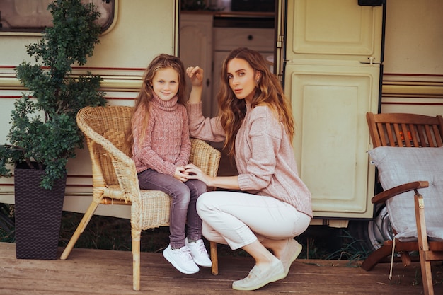 mère et petite fille se détendre et s'amuser dans la campagne en vacances camping car