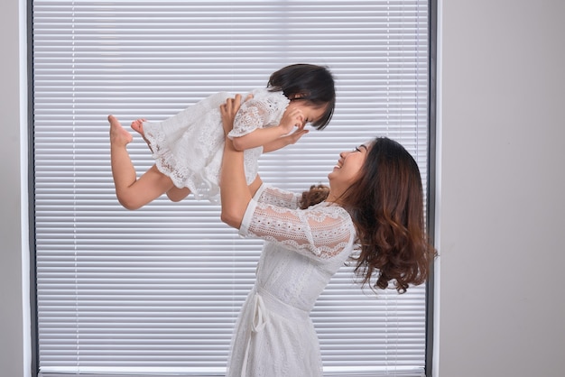 Mère et petite fille se moquer dans le salon.Rire.Mère tenant sa fille.