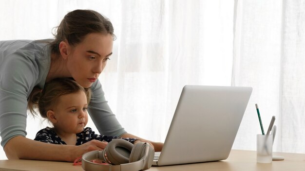 Mère et petite fille utilisant un ordinateur portable à la maison