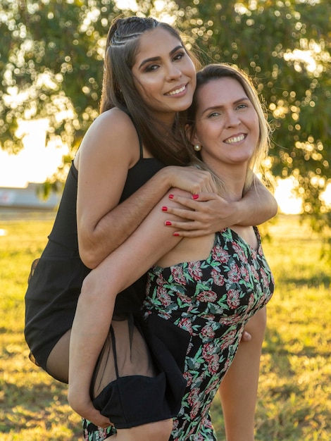 Photo mère portant sa fille au coucher du soleil