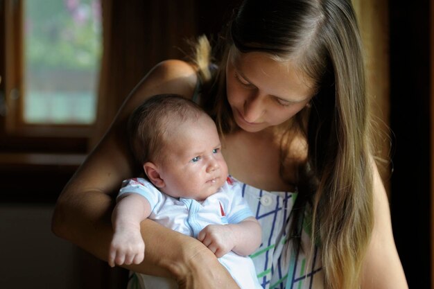 Mère portant son fils mignon tout en restant à la maison