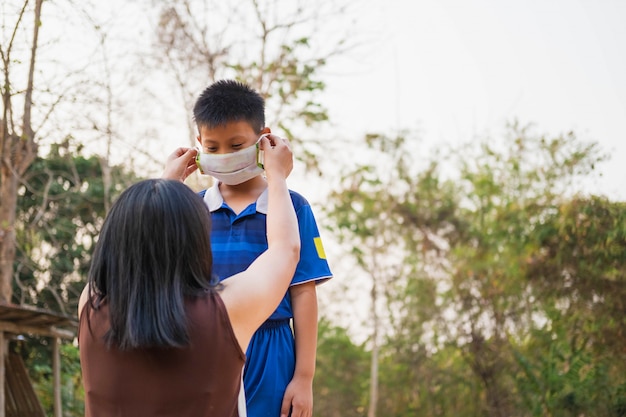 la mère porte un masque pour protéger son fils du virus covid-19.