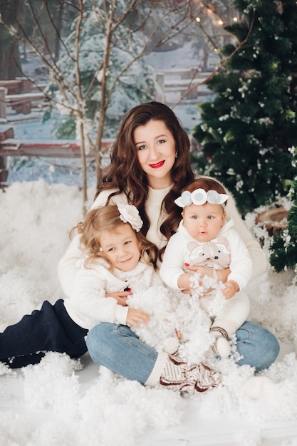 Mère posant ses deux filles le jour de Noël