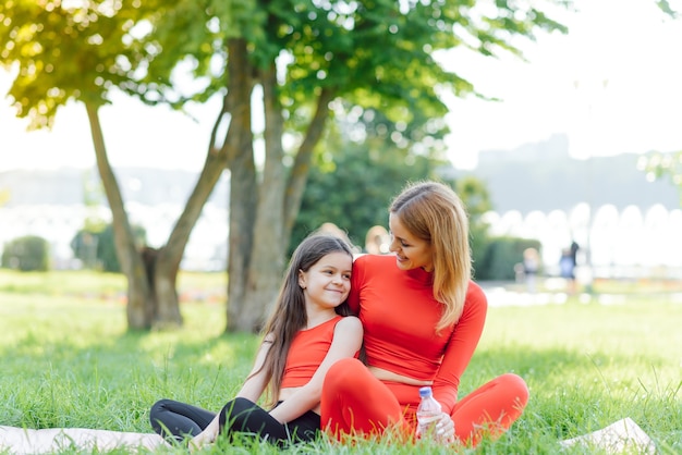 Mère pratiquant le yoga avec sa fille en plein air