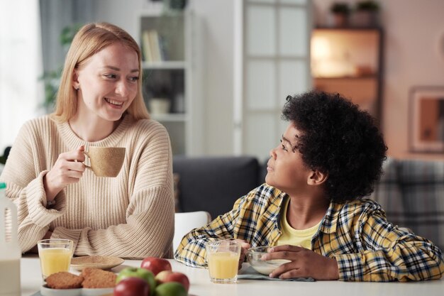 Mère prenant le petit déjeuner avec son garçon adoptif