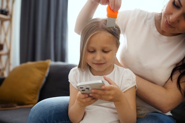 Mère prenant soin d'un enfant avec des poux de tête