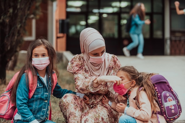 La mère prépare deux filles pour l'école Rentrée scolaire au moment de la pandémie de coronavirusNouvelle normalité L'éducation pendant la pandémie de Covid19 Mise au point sélective