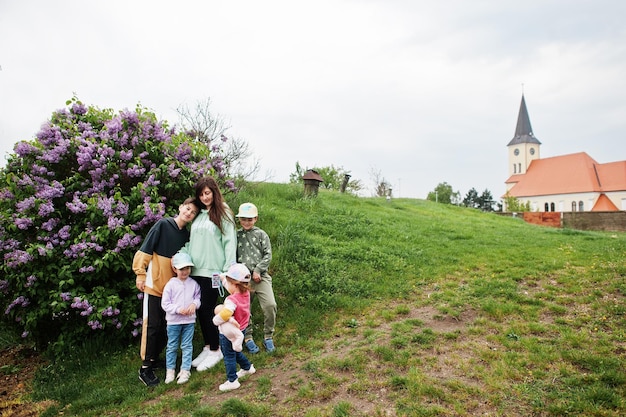 Une mère de quatre enfants se tient près d'un lilas