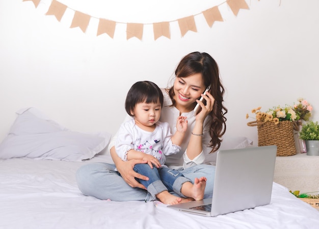 Mère qui travaille avec sa fille dans la chambre à la maison