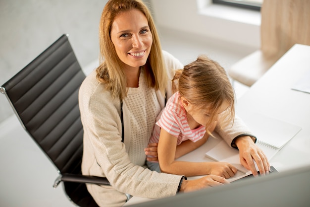 Mère qui travaille avec sa jolie fille au bureau