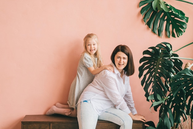 Mère en riant s'amuser avec sa petite fille expressive