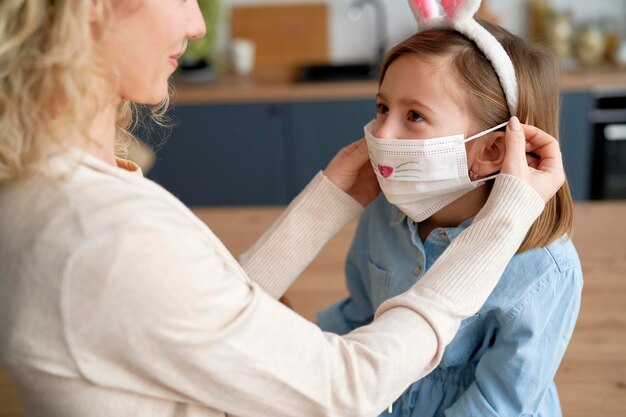 Une mère s'applique un masque de protection pour sa fille