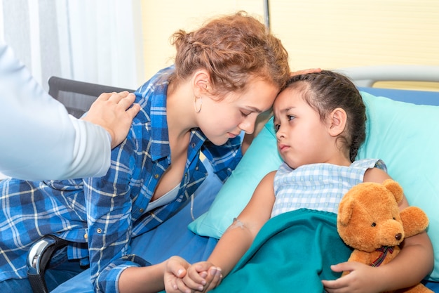 La mère s'embrasse, rassurant et discutant de sa fille. Patient fille triste sur l'hôpital de la chambre.