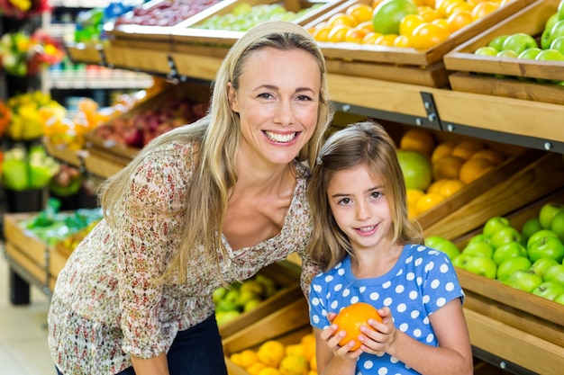 Mère avec sa fille achetant l&#39;orange