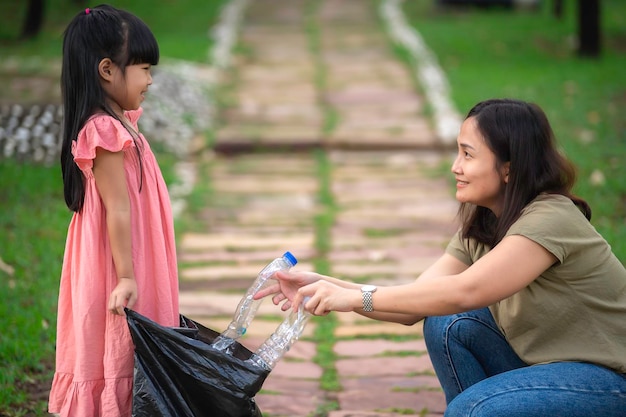 Une mère et sa fille asiatiques aident à collecter les ordures dans un environnement caritatif