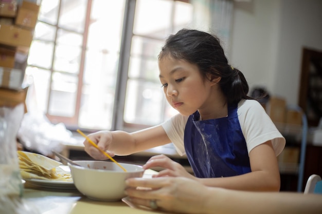 Une mère et sa fille asiatiques cuisinent et s'amusent dans la cuisine