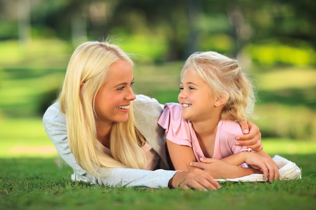 Mère avec sa fille couchée dans le parc