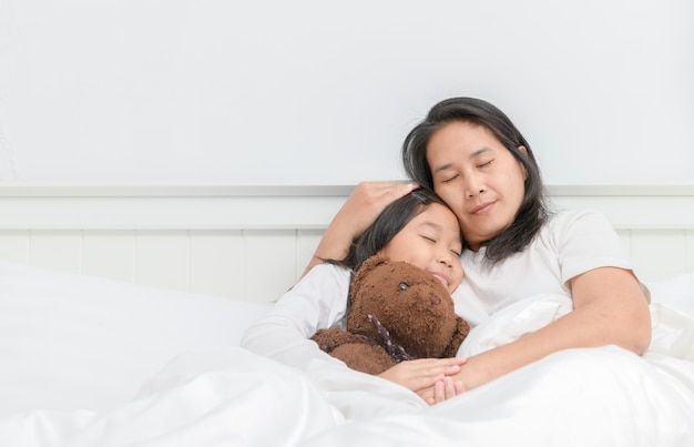 Mère et sa fille dormir sur lit