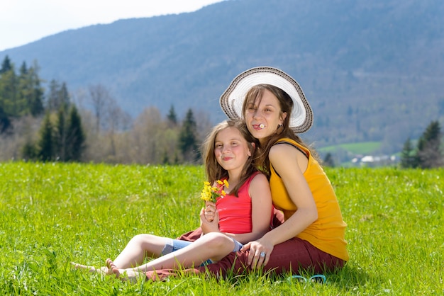 Une mère et sa fille avec une fleur dans la bouche