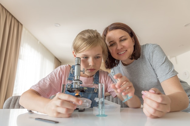 Une mère et sa fille font des expériences chimiques avec un microscope à la maison