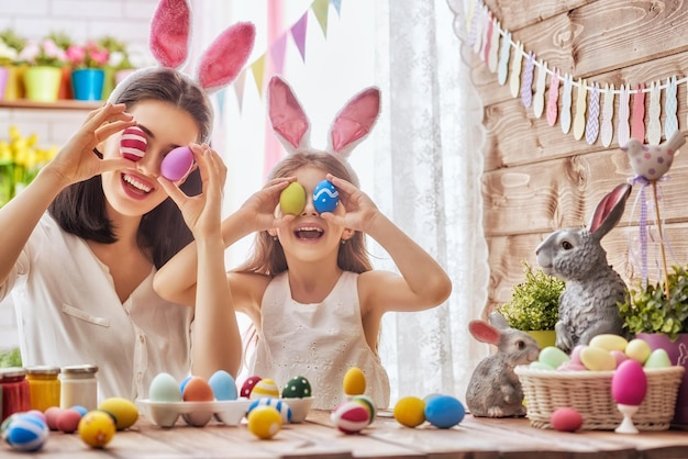 Photo mère et sa fille peignant des œufs famille heureuse se préparant pour pâques