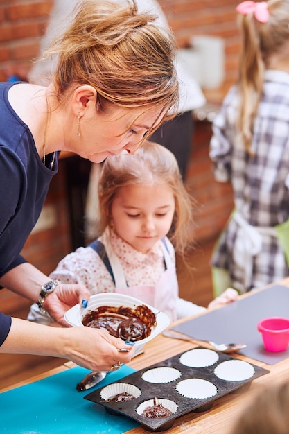 Une mère et sa fille préparent des cupcakes à la maison