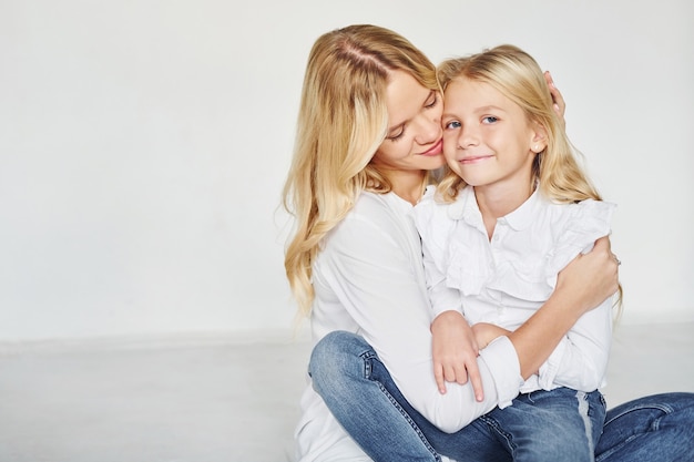 Mère avec sa fille s'amuser ensemble dans le studio avec fond blanc.