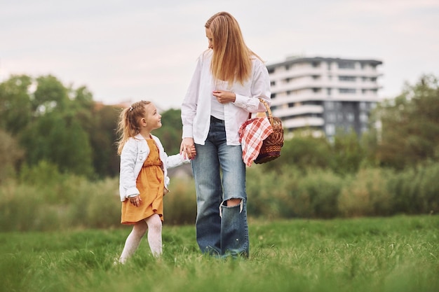 Mère avec sa jeune fille se promène à l'extérieur