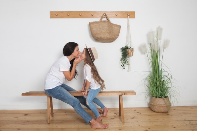 Mère et sa petite fille assise sur un banc à la maison