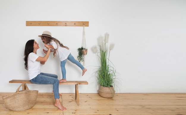 Mère et sa petite fille assise sur un banc à la maison