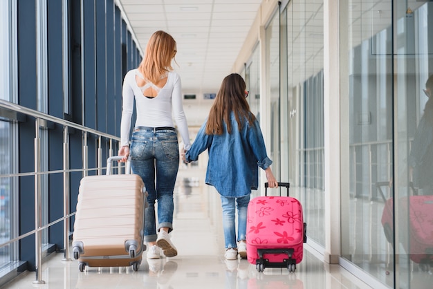 Mère et sa petite fille avec des bagages à l'aéroport