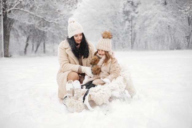 Mère et sa petite fille jouant à l'extérieur le jour de l'hiver